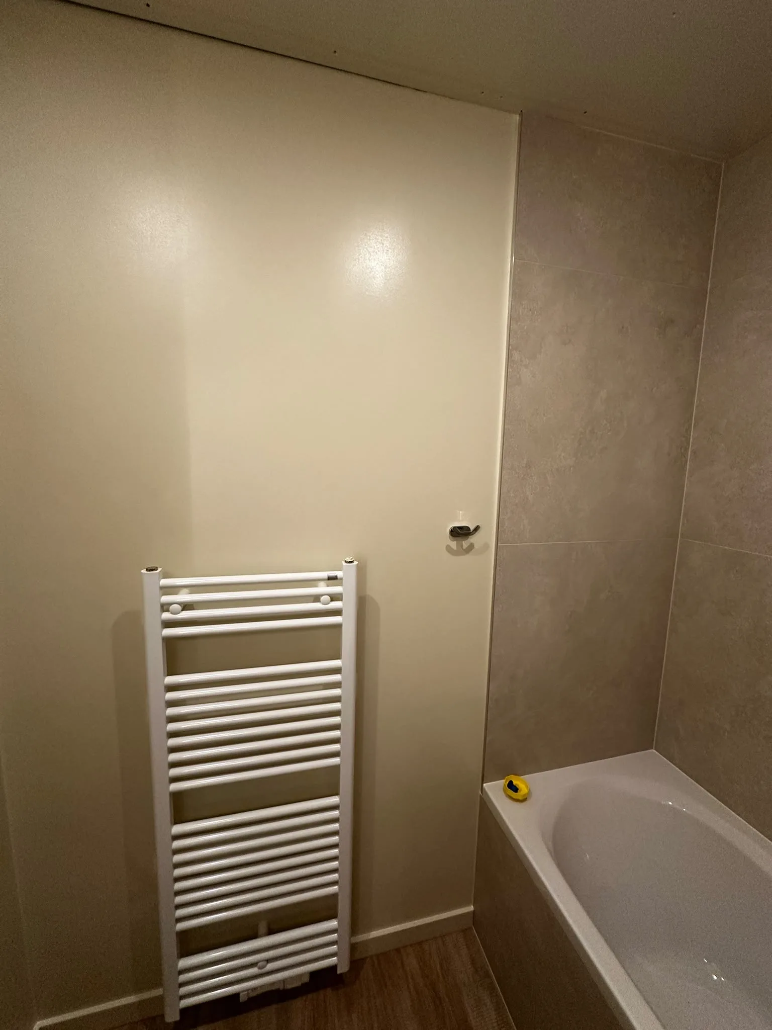White towel radiator beside the bath