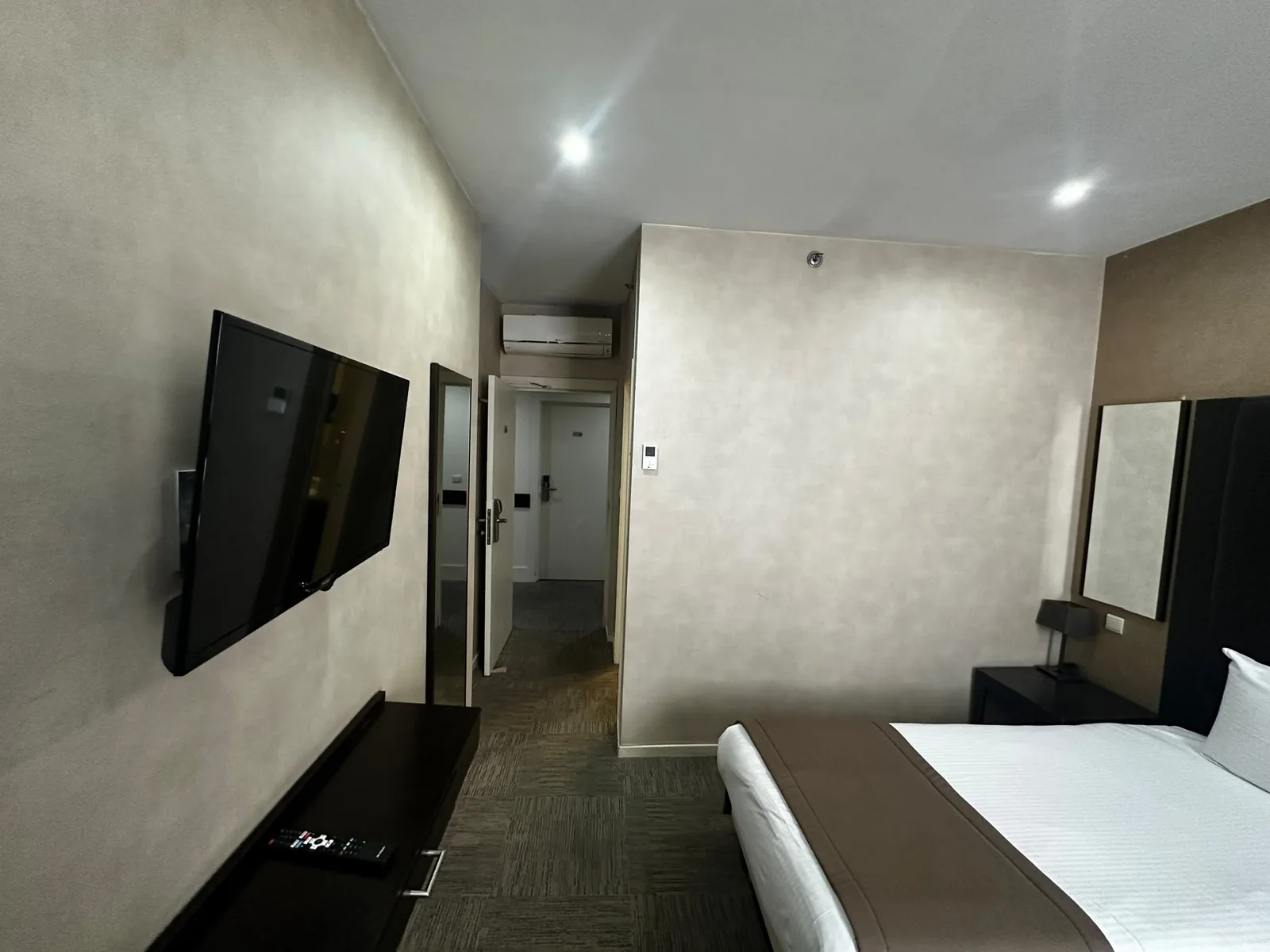 Previous room with neutral walls and dark furniture