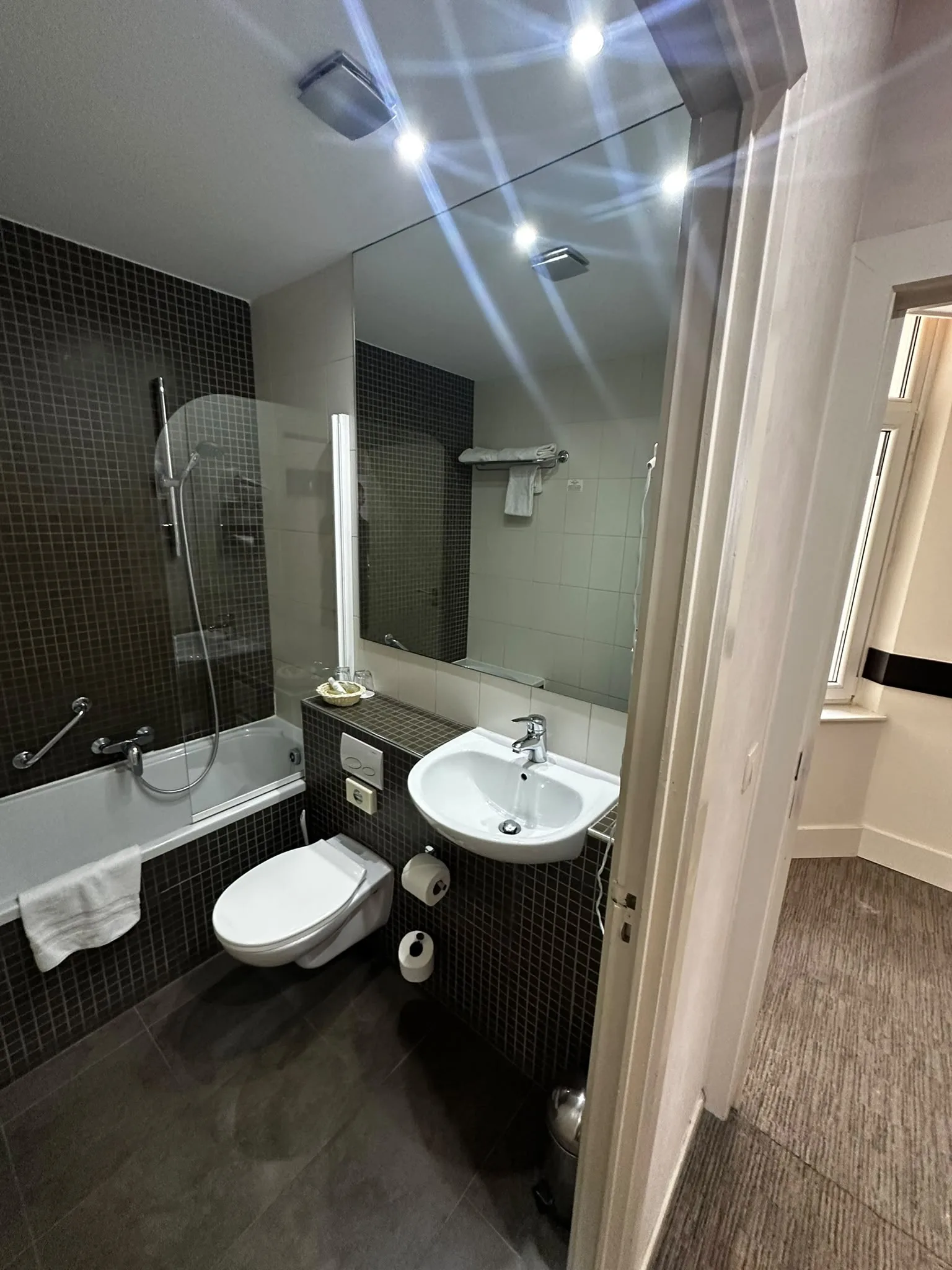 Previous bathroom with a bath and dark mosaic tiles