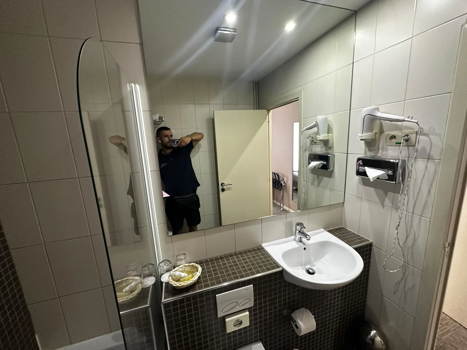 Previous basin and mirror above mosaic tiling