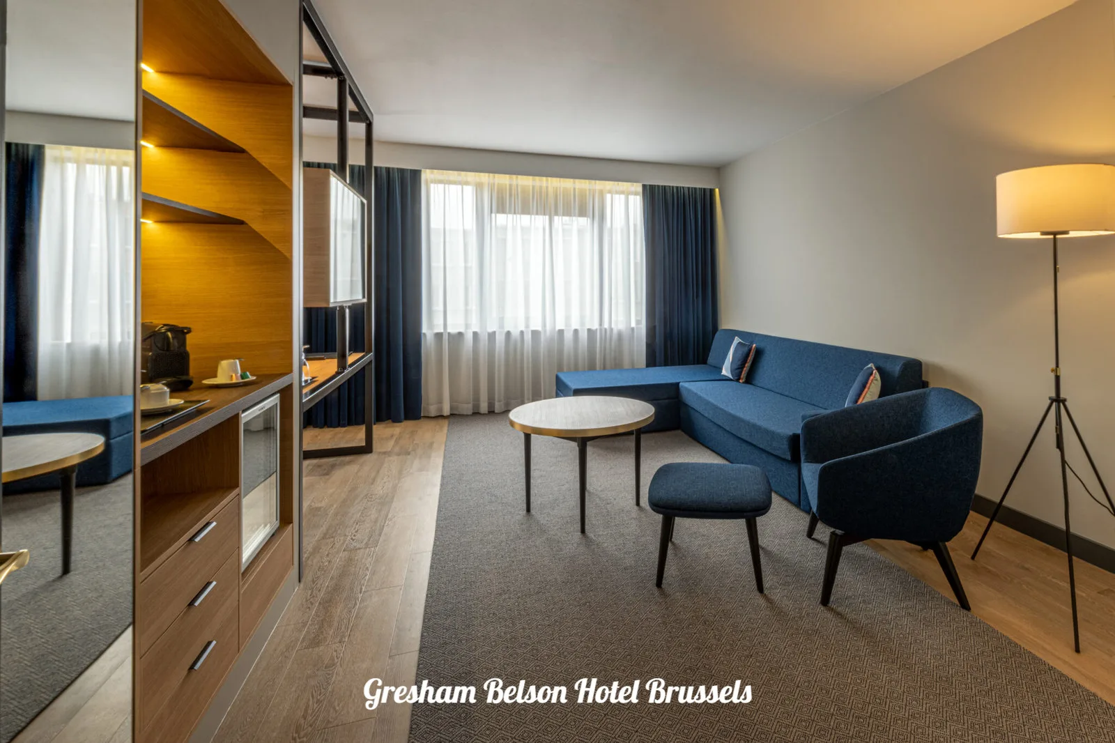 Hotel suite with a seating area and large windows