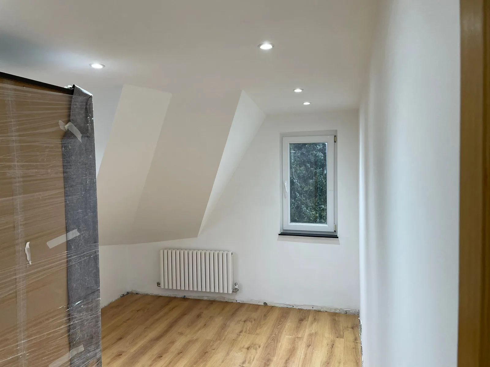 Room beneath the roof with recessed lighting