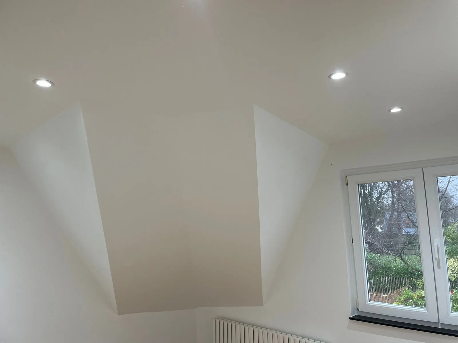 Room beneath the roof with recessed lighting