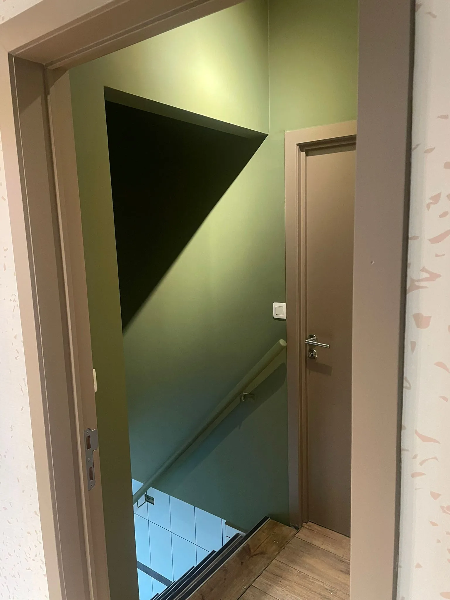 Staircase with green-toned walls