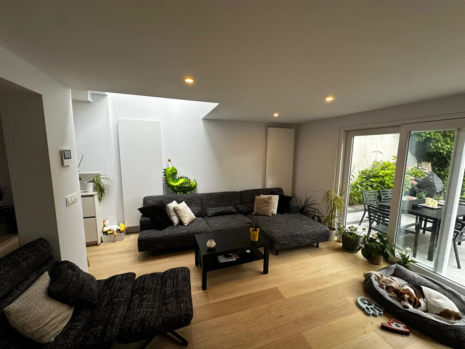 Salon avec spots encastrés et baie vitrée vers la terrasse