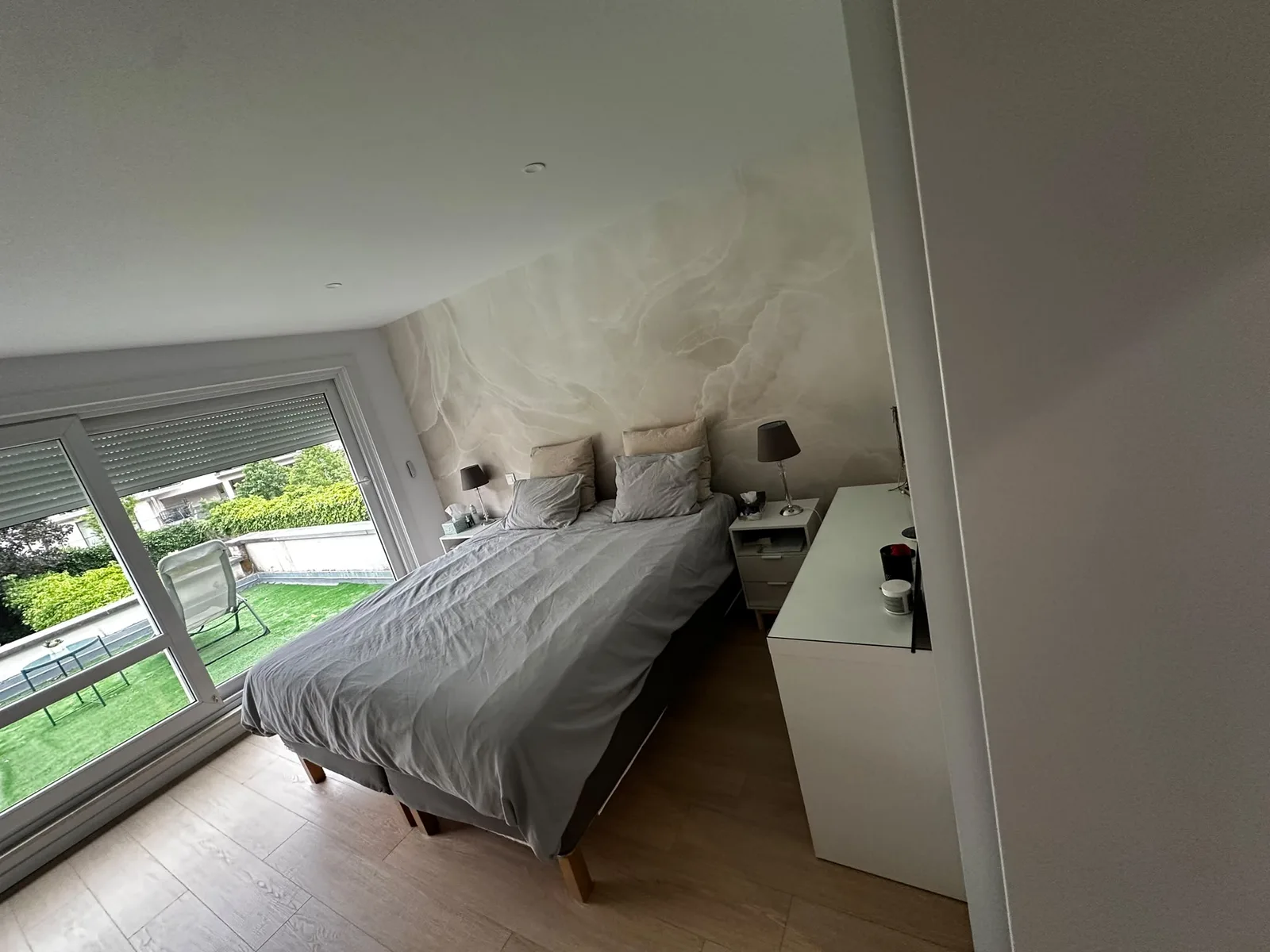 Chambre principale avec mur décoratif aux tons clairs
