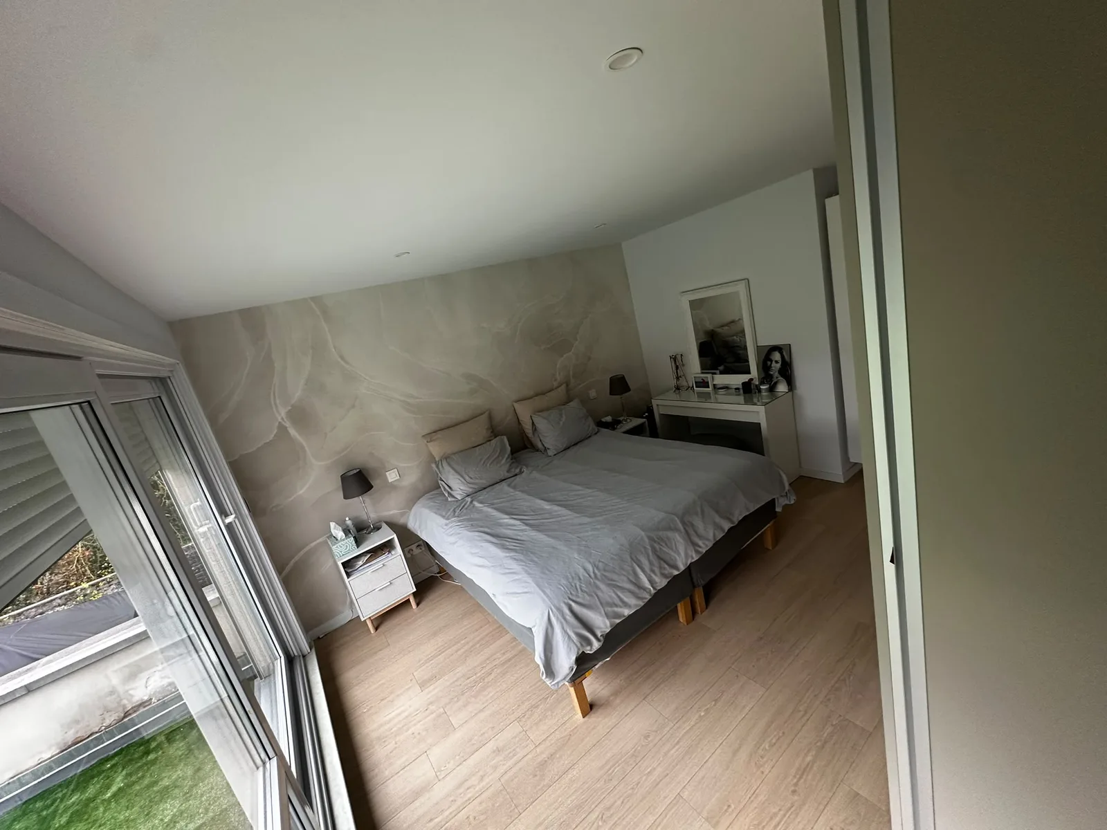 Chambre principale avec éclairage encastré et mur décoratif