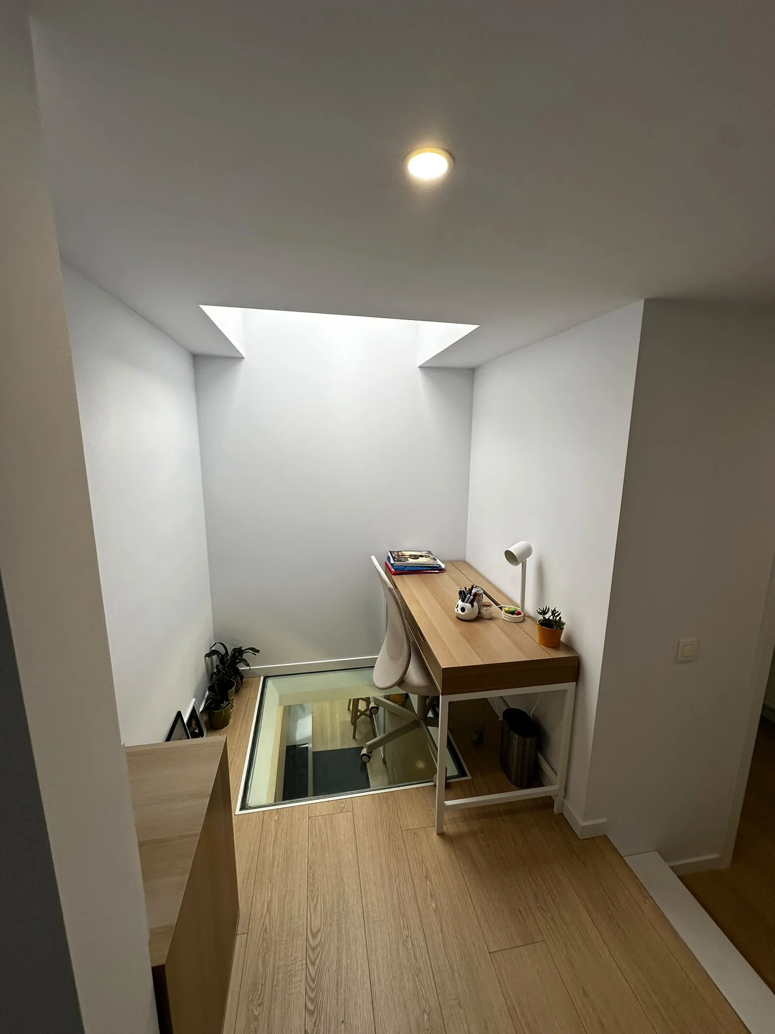Coin bureau sous un puits de lumière et dalle vitrée au sol