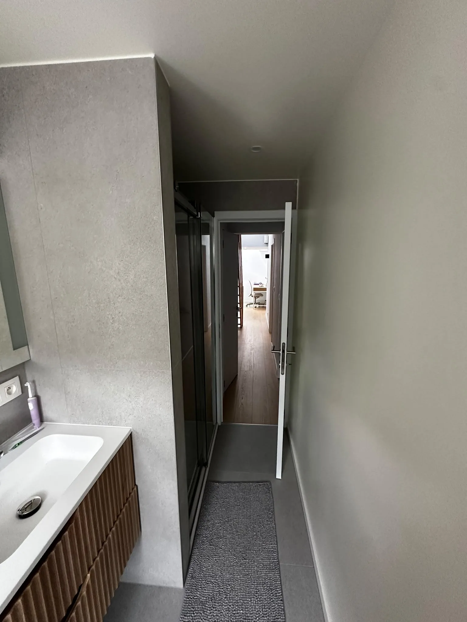 Carrelage gris et passage de la salle de bain vers le palier
