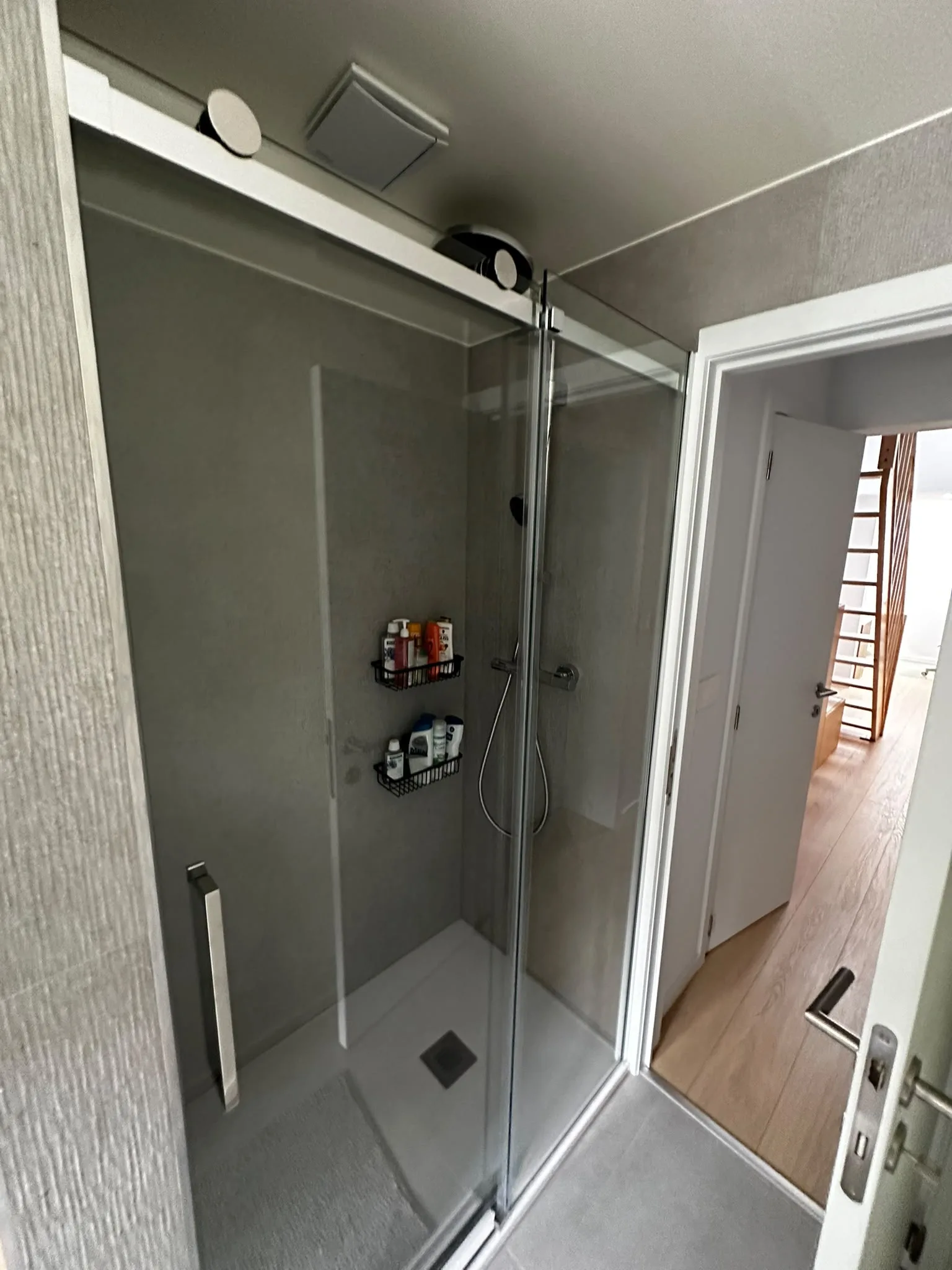 Douche vitrée avec robinetterie chromée et receveur blanc