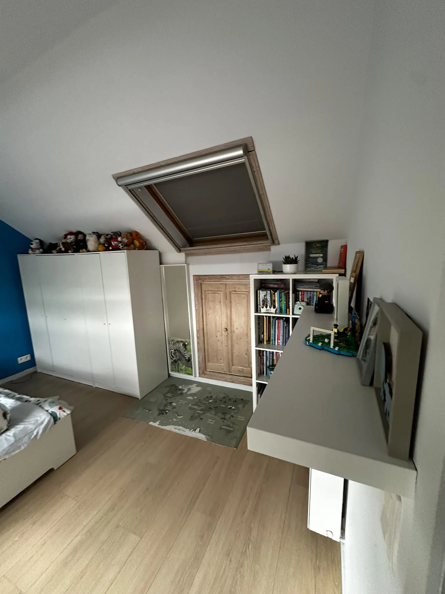 Chambre mansardée avec fenêtre de toit et rangements