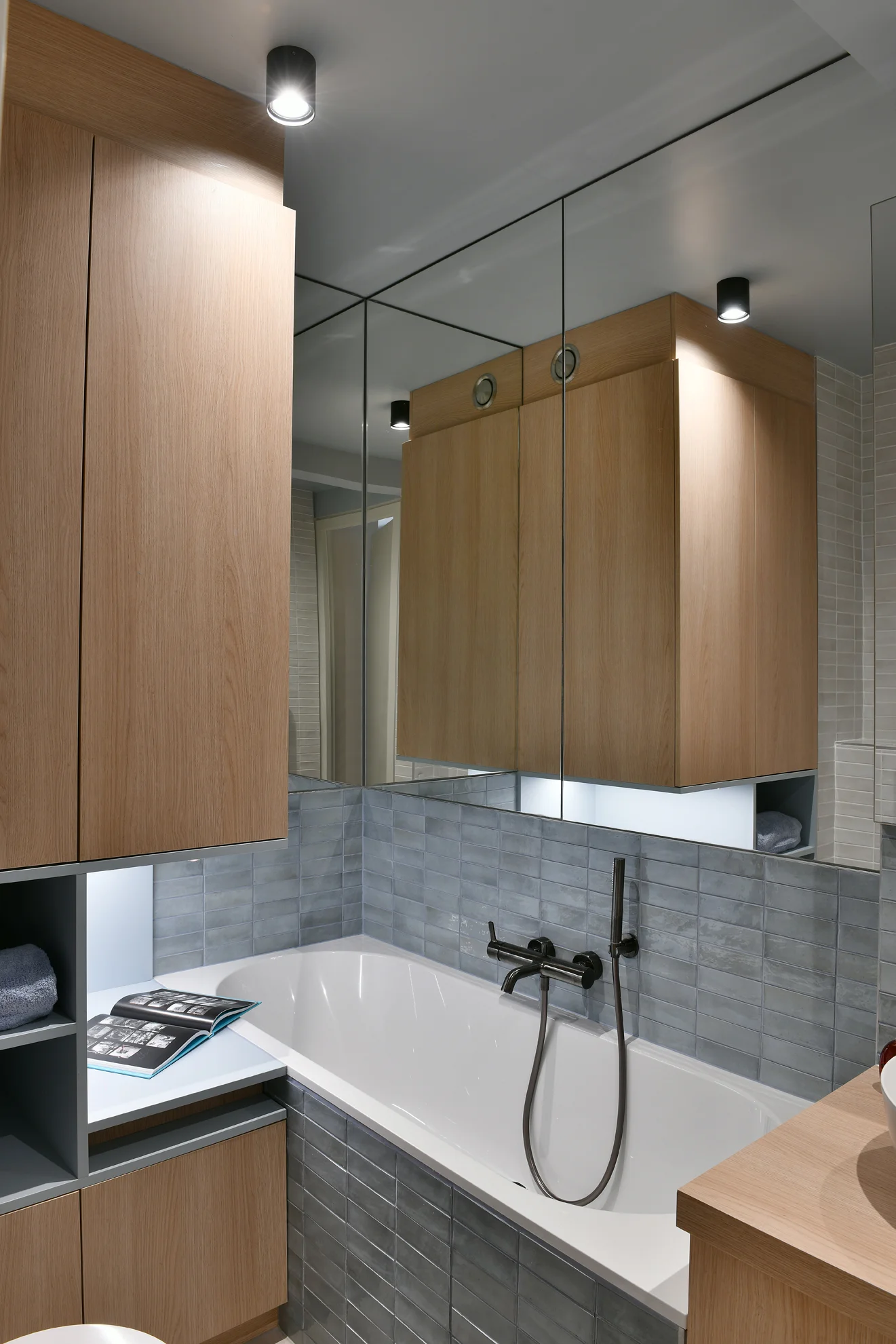 Bath with black fittings and timber storage