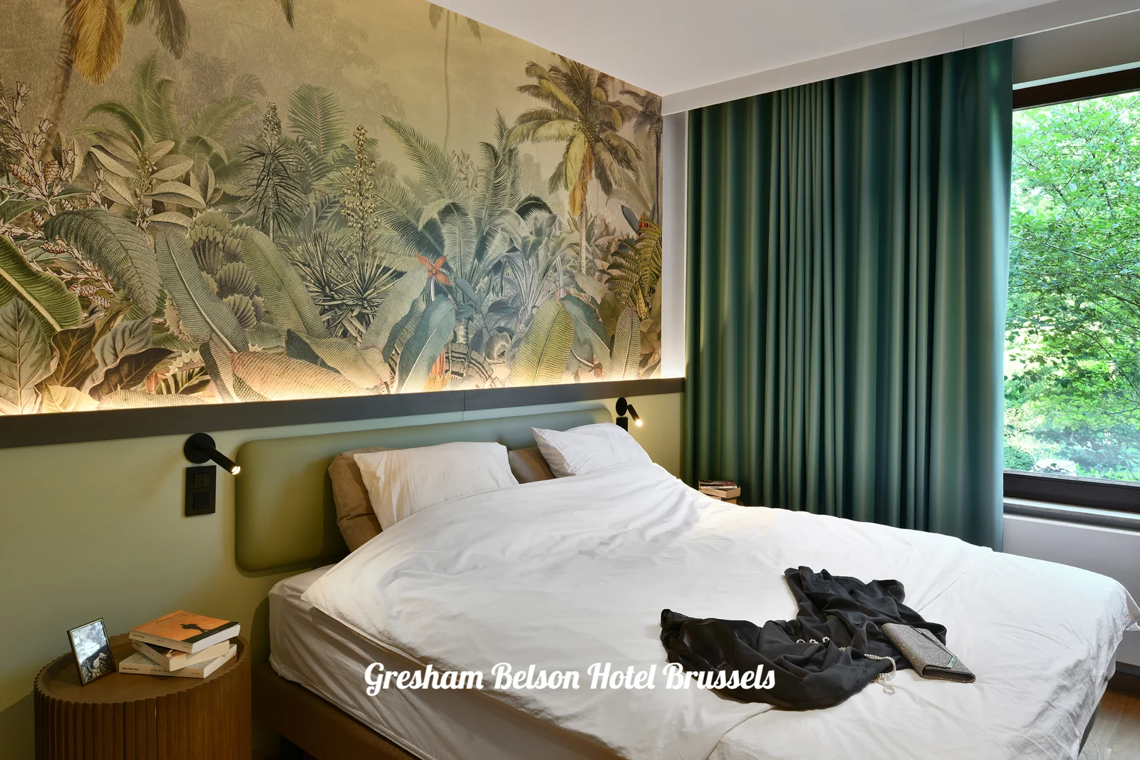 Room with a botanical wall, green headboard and window