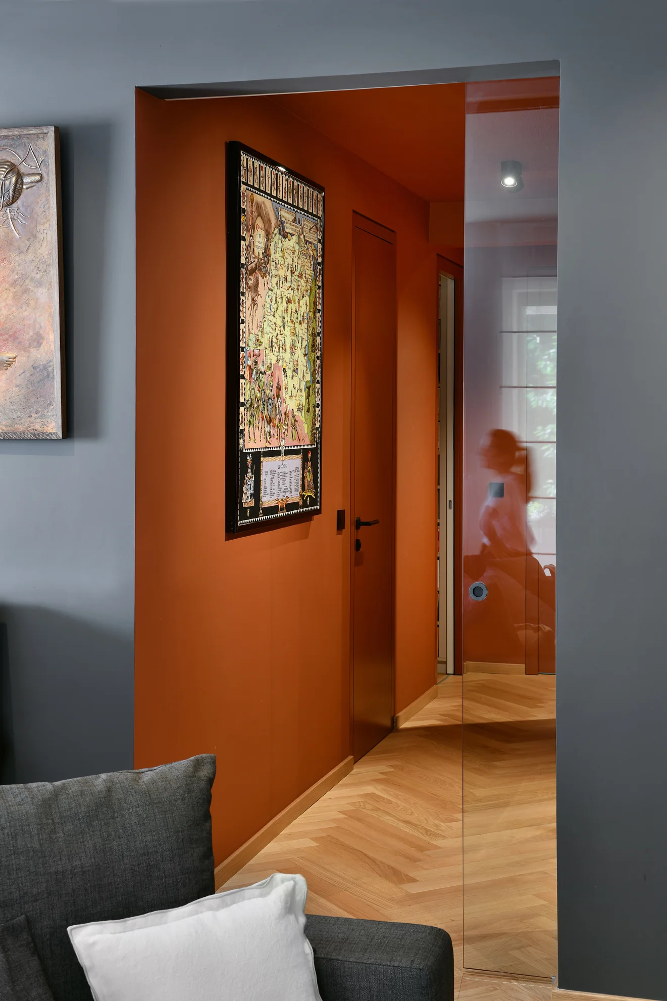 Orange door and a passage into a room with parquet