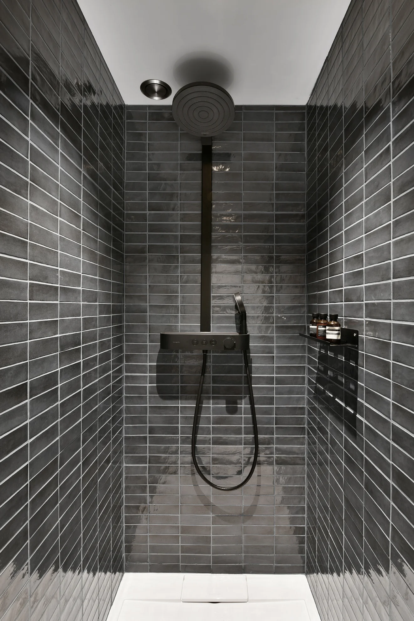 Shower with grey tiles and black fittings