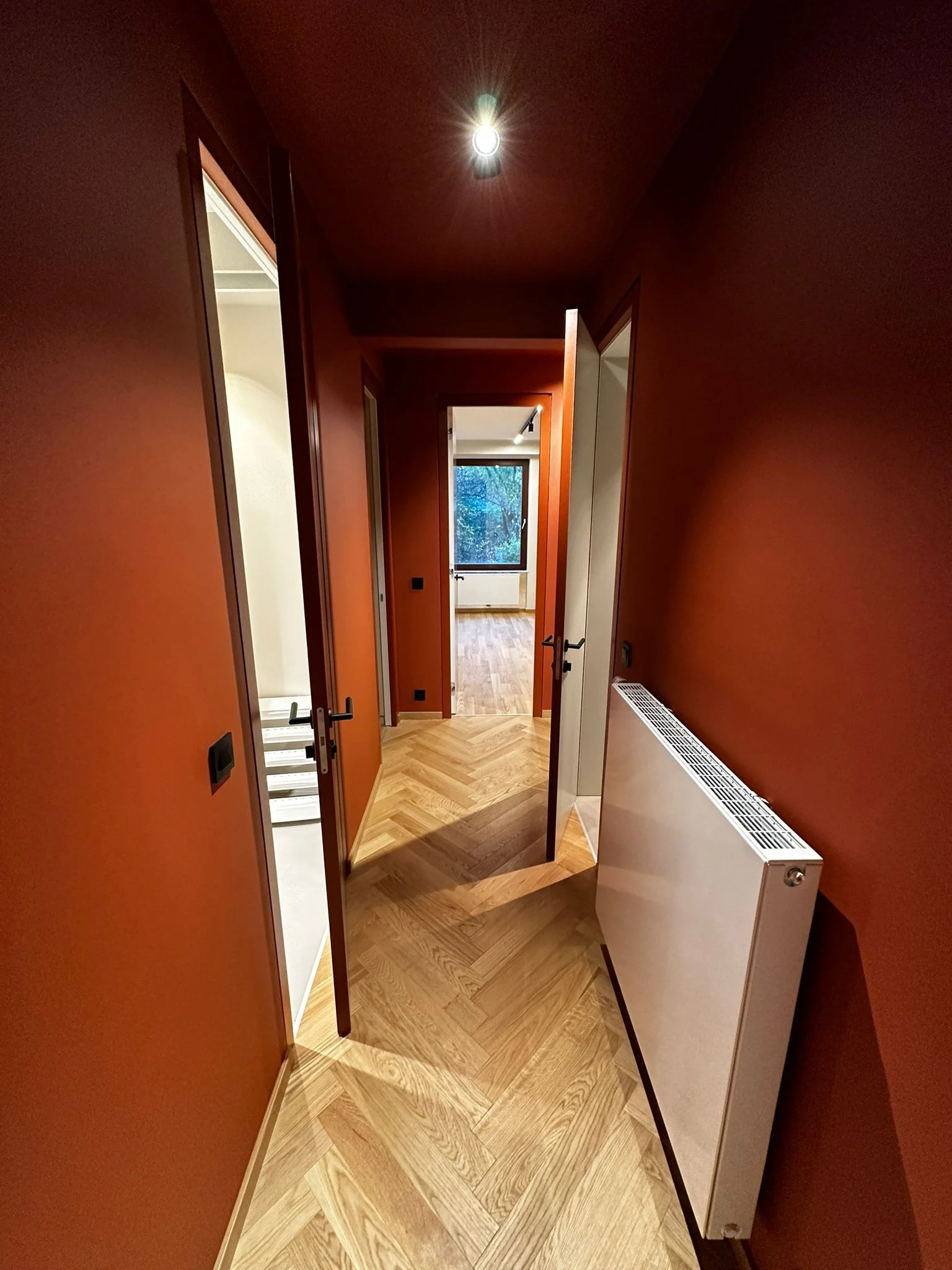 Corridor with red walls, parquet and lighting